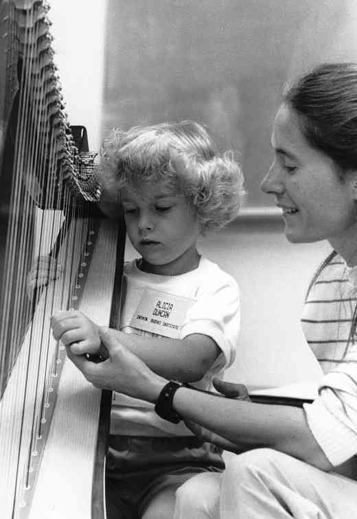 Mary Kay Waddington gives a harp lesson at Intermountain Suzuki Institute